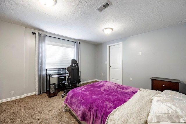 bedroom with carpet, baseboards, and a textured ceiling