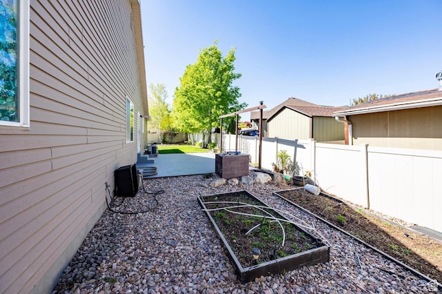 fenced backyard featuring a garden and central air condition unit