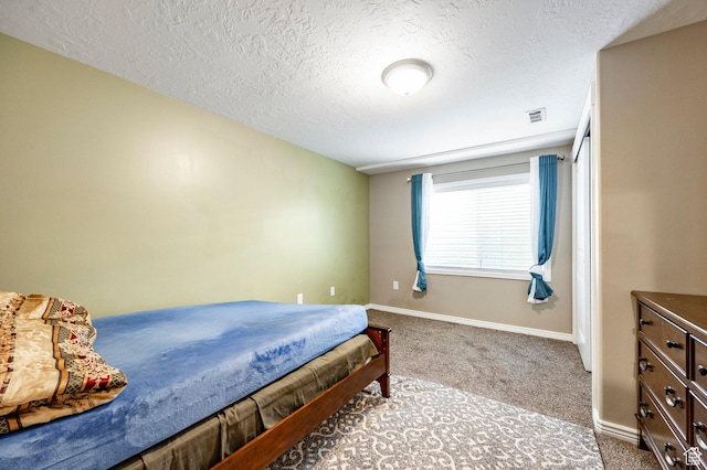 bedroom with carpet, a textured ceiling, and baseboards