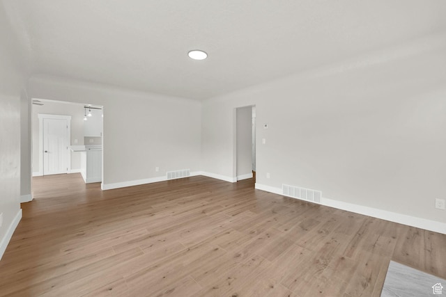 empty room with baseboards and light wood-type flooring
