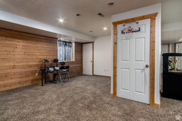 below grade area featuring wood walls, carpet, and recessed lighting