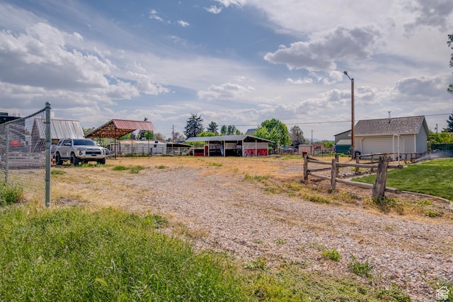 view of dirt / gravel road featuring street lights