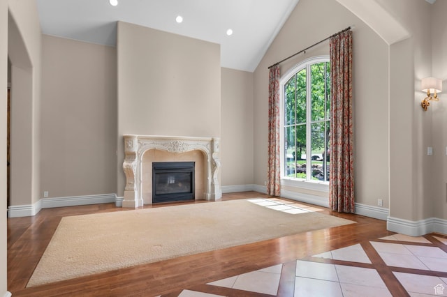 81 E Lone Hollow Dr S, Sandy, UT 84092 - unfurnished living room with a high end fireplace, baseboards, recessed lighting, inlaid floor details, and vaulted ceiling
