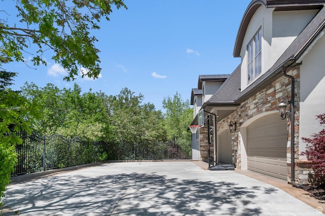 81 E Lone Hollow Dr S, Sandy, UT 84092 - view of property exterior featuring stone siding, stucco siding, fence, and a garage