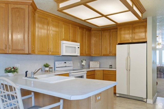 269 River Cove Dr, Morgan, UT 84050 - kitchen featuring white appliances, a peninsula, light countertops, a sink, and a breakfast bar area