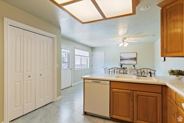 269 River Cove Dr, Morgan, UT 84050 - kitchen featuring white dishwasher, a sink, a peninsula, brown cabinets, and a textured ceiling