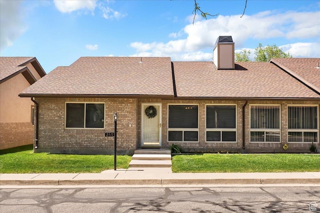 269 River Cove Dr, Morgan, UT 84050 - view of property with roof with shingles, a front yard, a chimney, and brick siding