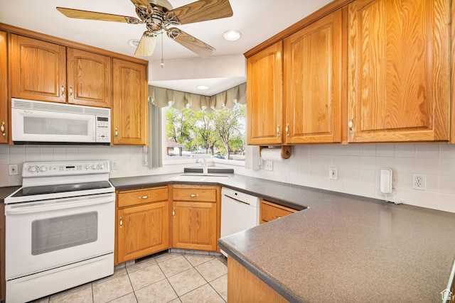 kitchen featuring white appliances, a sink, dark countertops, backsplash, and recessed lighting