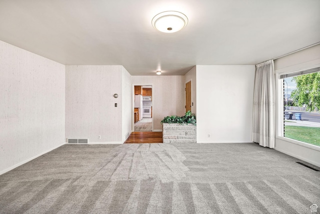 carpeted empty room featuring baseboards