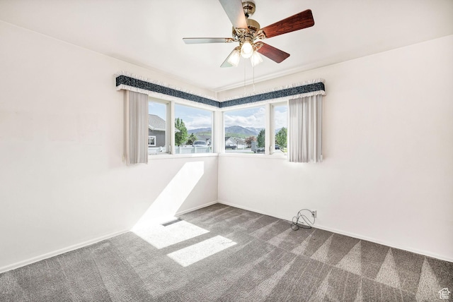 spare room with carpet flooring, a ceiling fan, and baseboards