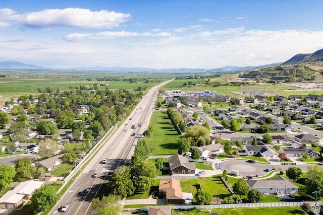 aerial view of residential area featuring a mountain backdrop and a main thoroughfare