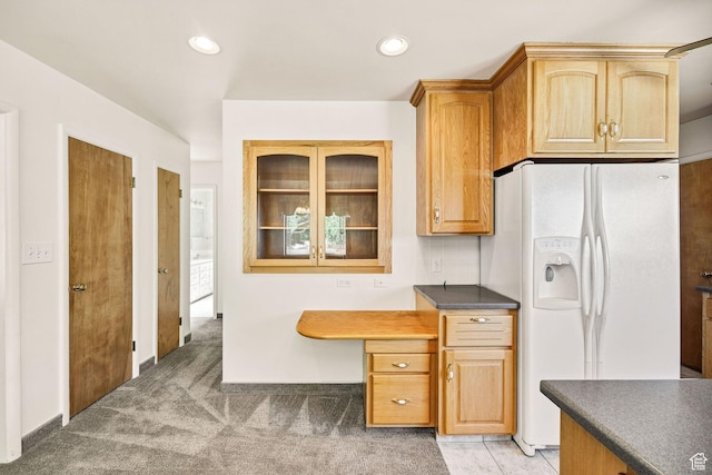 kitchen with white fridge with ice dispenser, dark countertops, light carpet, and recessed lighting