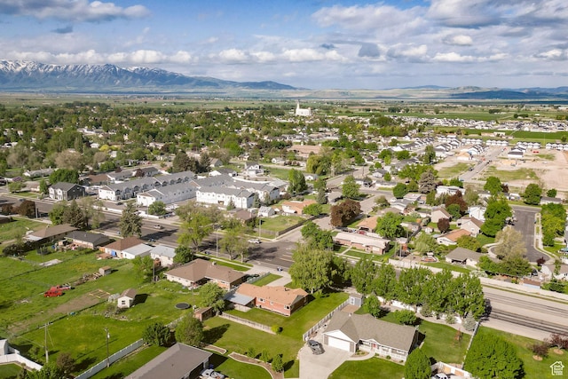 aerial view of property and surrounding area featuring a mountainous background and nearby suburban area