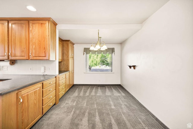 kitchen featuring carpet, a chandelier, decorative backsplash, dark countertops, and decorative light fixtures