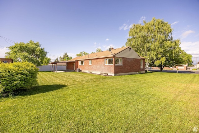 back of house featuring a yard and brick siding