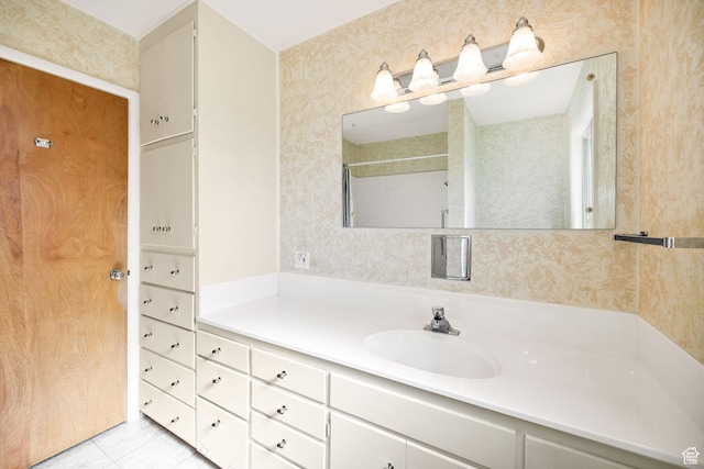 full bath featuring vanity, tile patterned flooring, and a shower