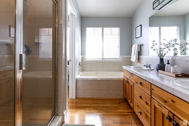 full bath featuring hardwood / wood-style floors, healthy amount of natural light, and a stall shower