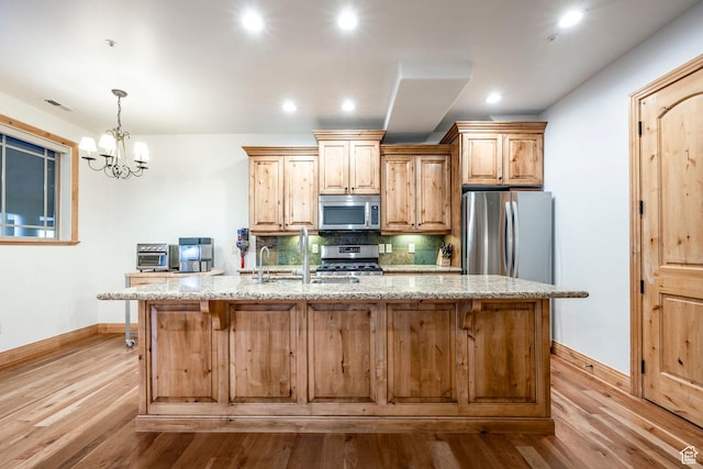 3033 Canyon Links Dr, Park City, UT 84098 - kitchen with stainless steel appliances, baseboards, wood finished floors, an island with sink, and tasteful backsplash