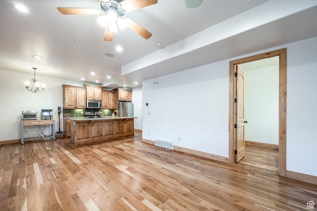 3033 Canyon Links Dr, Park City, UT 84098 - kitchen with appliances with stainless steel finishes, light wood-style flooring, recessed lighting, light countertops, and a center island with sink