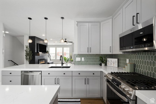 3478 S Wick Ct Unit 61, South Salt Lake, UT 84115 - kitchen featuring stainless steel appliances, a sink, light countertops, a peninsula, and tasteful backsplash