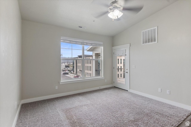 carpeted empty room featuring a ceiling fan, lofted ceiling, and baseboards