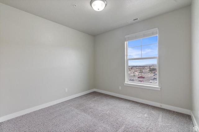 carpeted empty room featuring baseboards