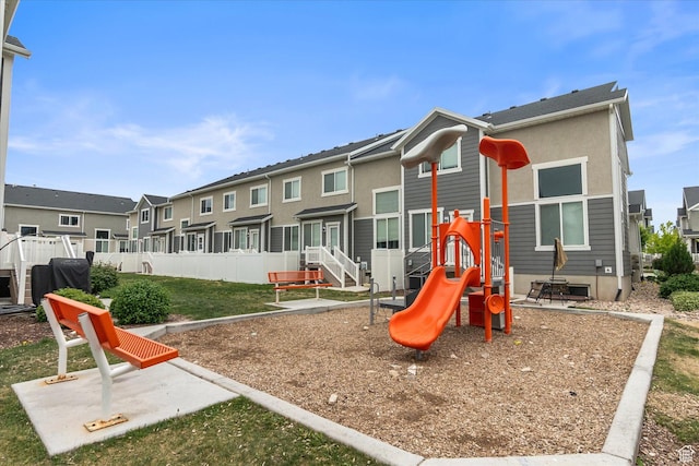 community play area with a residential view and fence