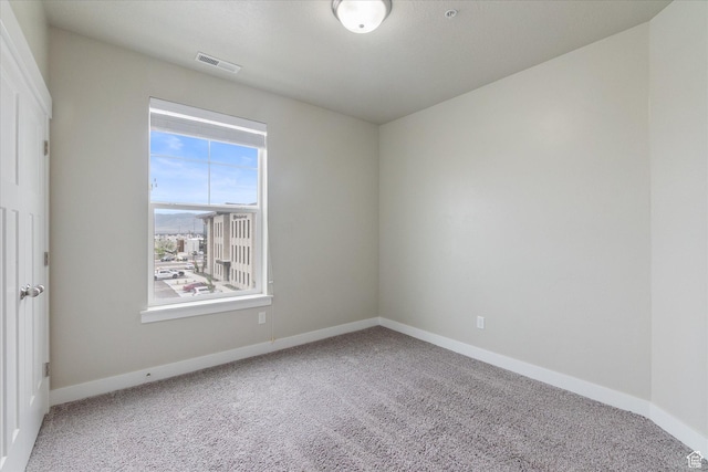 carpeted empty room featuring baseboards
