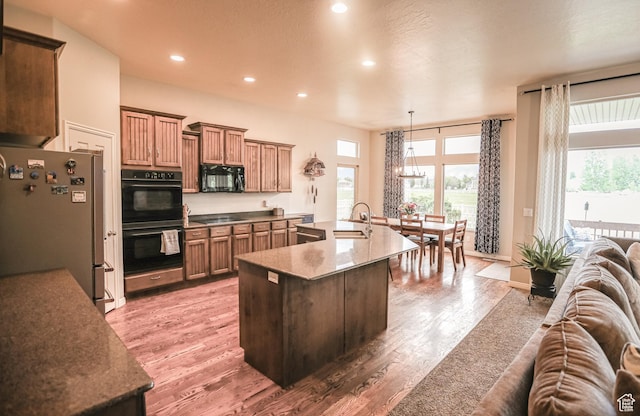 2817 S 1415 W, Syracuse, UT 84075 - kitchen featuring black appliances, open floor plan, light wood-type flooring, recessed lighting, and healthy amount of natural light