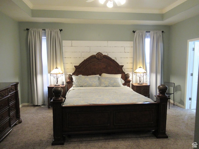 carpeted bedroom with a raised ceiling and ornamental molding