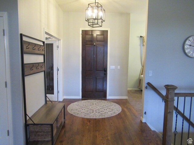 entrance foyer with a chandelier, wood finished floors, and baseboards