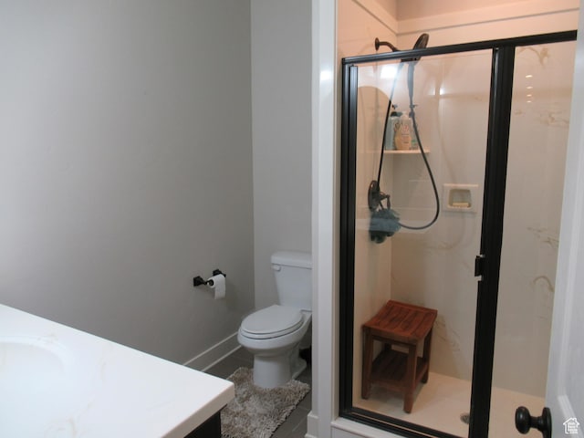 full bathroom with a stall shower, toilet, and vanity