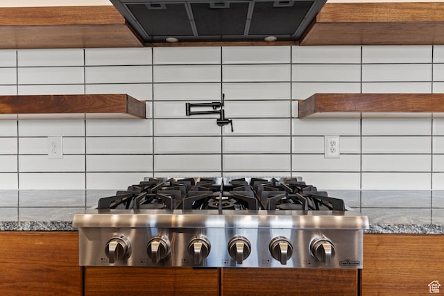 1885 N 2000 E, North Logan, UT 84341 - kitchen view of exhaust hood, stainless steel gas stovetop, backsplash, dark stone counters, and brown cabinets