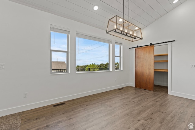 1885 N 2000 E, North Logan, UT 84341 - unfurnished bedroom featuring multiple windows, baseboards, a barn door, wood finished floors, and recessed lighting
