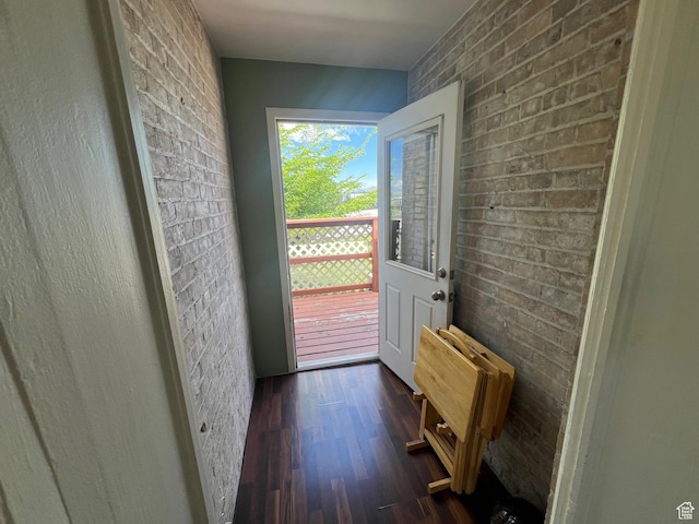 entryway with radiator, dark wood-style flooring, and brick wall