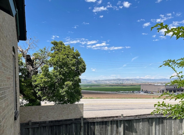 water view featuring fence and a mountain backdrop
