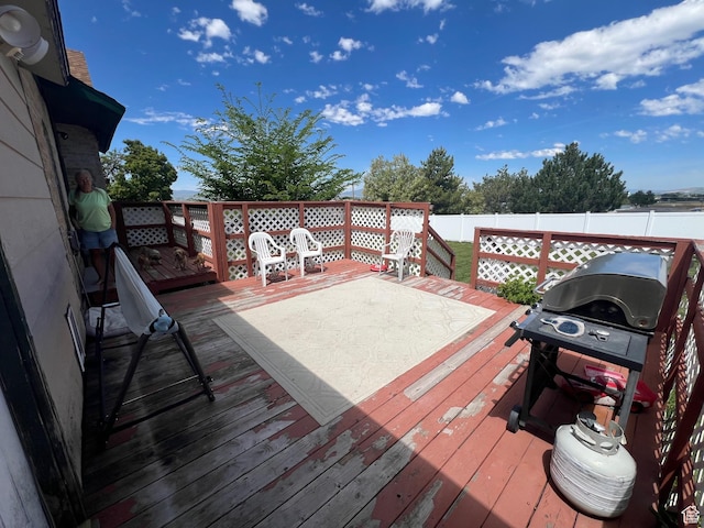 deck with a fenced backyard and a grill