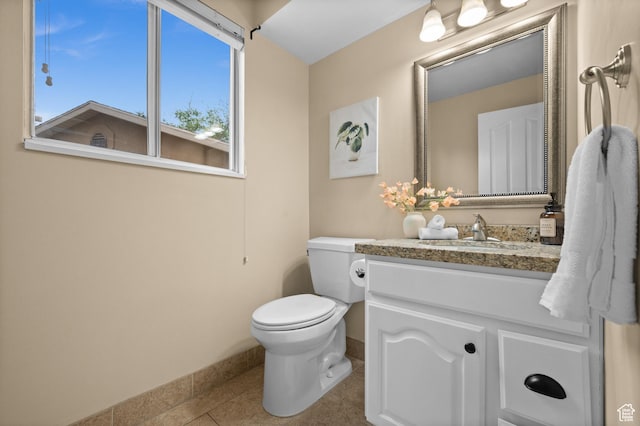 bathroom with baseboards, vanity, tile patterned floors, and toilet