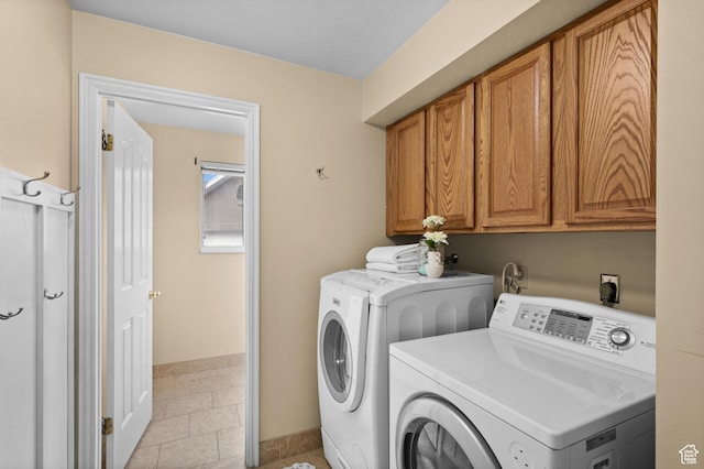 washroom featuring cabinet space, washing machine and dryer, and baseboards