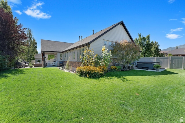 5982 N Rollins Ranch Rd W, Mountain Green, UT 84050 - rear view of property with a hot tub, a patio, and a shingled roof