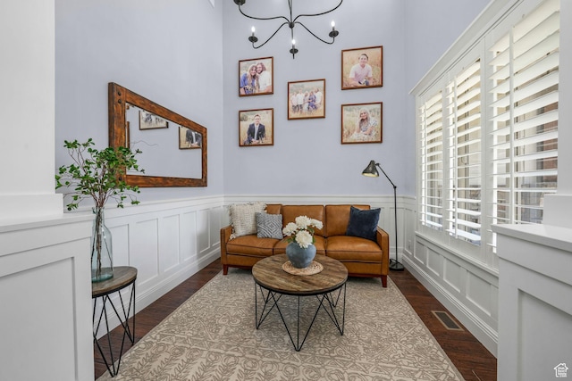 5982 N Rollins Ranch Rd W, Mountain Green, UT 84050 - living area with dark wood-type flooring, a chandelier, a wainscoted wall, and a decorative wall