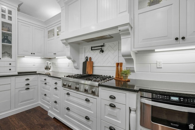 5982 N Rollins Ranch Rd W, Mountain Green, UT 84050 - kitchen featuring stainless steel appliances, white cabinetry, tasteful backsplash, dark wood-style flooring, and glass insert cabinets