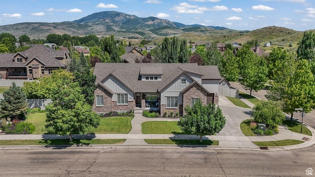 5982 N Rollins Ranch Rd W, Mountain Green, UT 84050 - view of front of property featuring board and batten siding, driveway, a mountain view, stone siding, and a garage