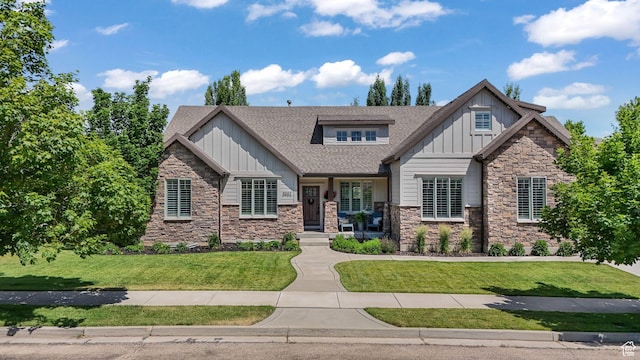 5982 N Rollins Ranch Rd W, Mountain Green, UT 84050 - craftsman house with board and batten siding, stone siding, a front yard, and a shingled roof