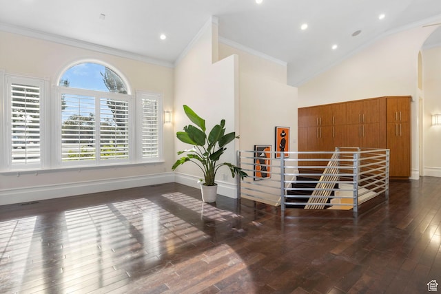 interior space featuring hardwood / wood-style flooring, arched walkways, high vaulted ceiling, baseboards, and ornamental molding