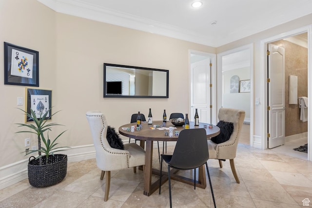 dining space featuring crown molding, baseboards, and light tile patterned flooring