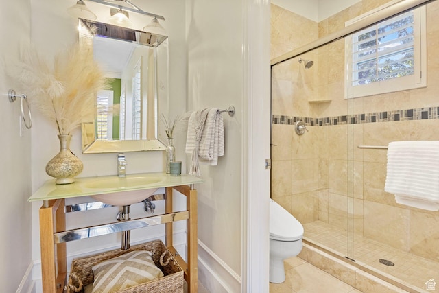 full bath featuring toilet, a stall shower, a sink, and baseboards