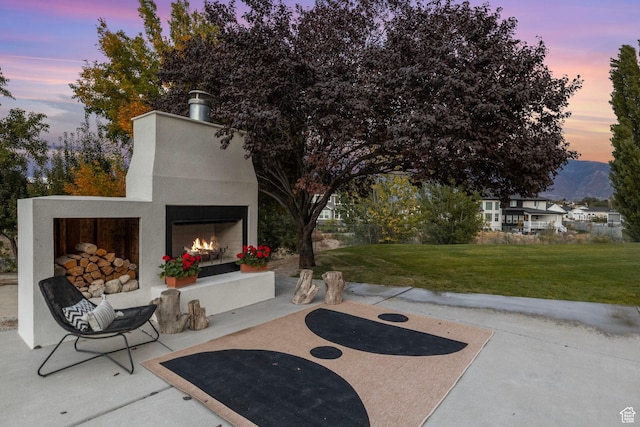 view of patio with a warm lit fireplace