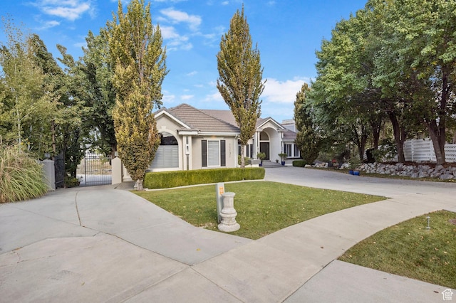 view of front facade featuring a gate, concrete driveway, stucco siding, and a tiled roof