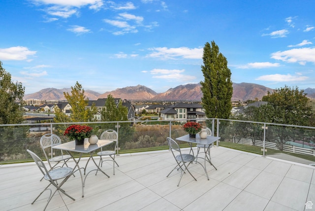 view of patio featuring a mountain view, a balcony, and a residential view